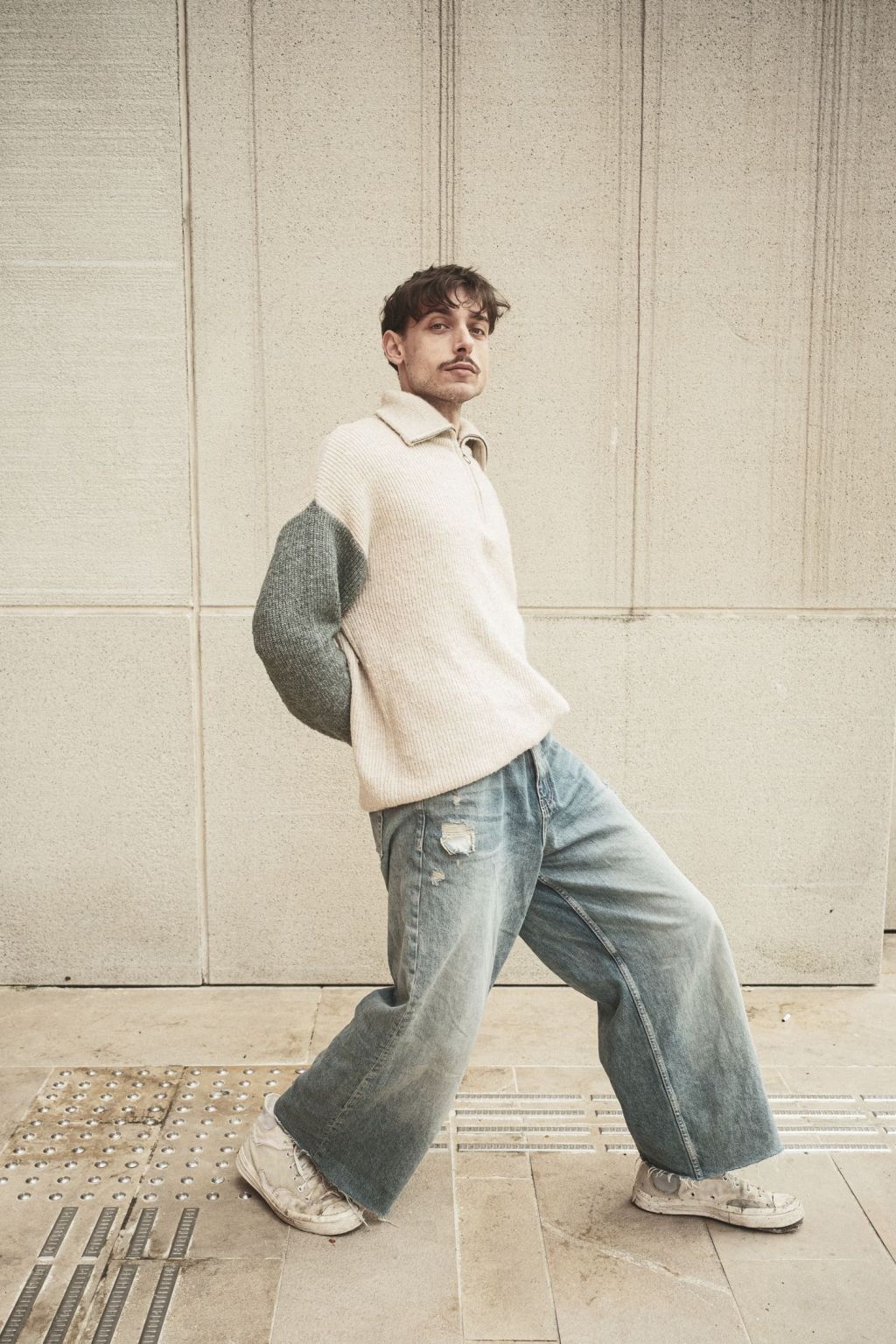 Man wearing loose baggy jeans and casual streetwear in an urban setting